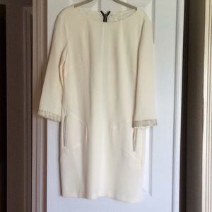 Off white dress with gold trim.